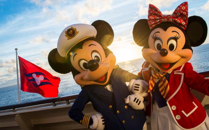 mickey mouse and minnie mouse on board a ship with a disney flag